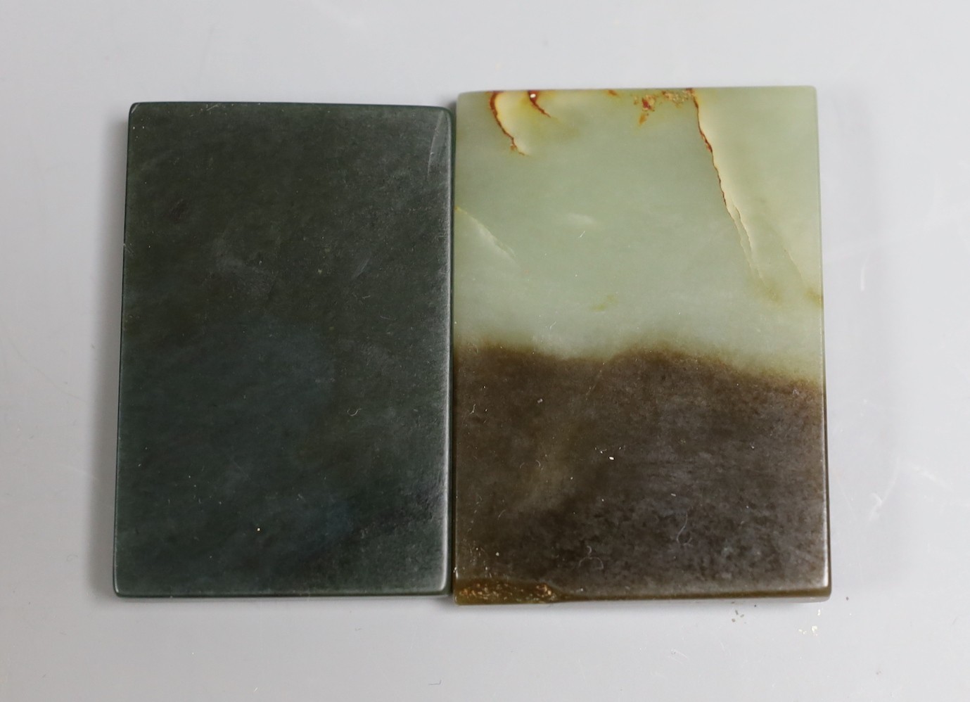 A Chinese russet and pale celadon jade plaque, 6.2cm and another green jade plaque